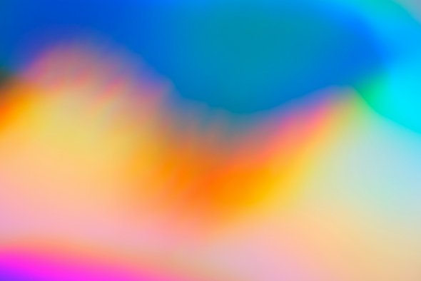 An abstract gradient background with smooth transitions between vibrant colors, including blue, green, yellow, orange, and pink. The colors blend seamlessly, creating a soft and dreamy effect.