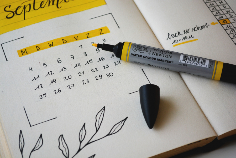 calendar drawn on a thick paper notebook with black and yellow marker