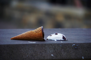 An ice cream cone dropped on top of a concrete top