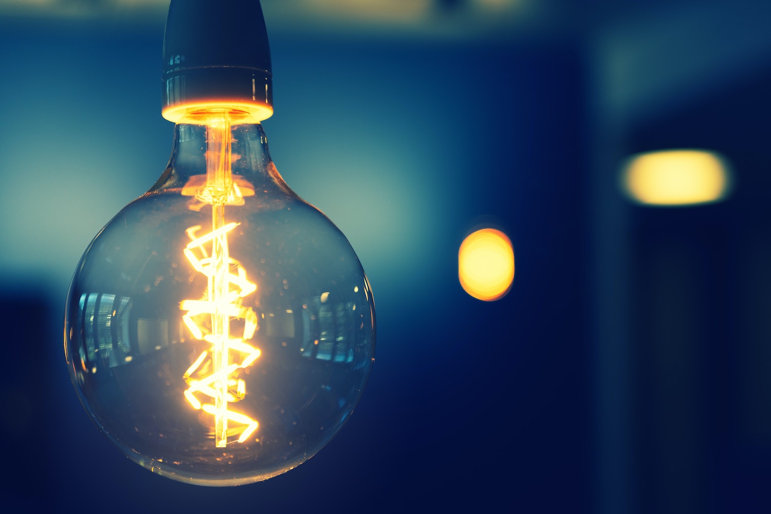a rustic light bulb to the left of the photo against a blurry moody background